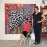 The artist and her dog in front of painting