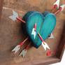 Sculptural Art, Shadow Box Style. The art piece has a solid wood heart sculpture with 7 handmade arrows. The tips and back of the arrow are hand made from aluminum plates.
The title of the artwork has an acrylic plate on top.