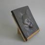 This bronze plaque depicts the head of a Siamese cat; it comes with a wooden stand but is also fit to hang on the wall.