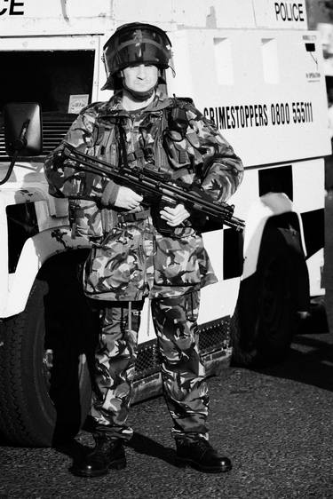 armed british army soldier in front of psni landrover thumb