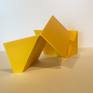 An bright yellow abstract sculpture examining volume and shapes.