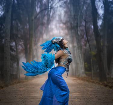 Freedom, Beautiful young woman with dress made of blue feathers, angel fallen from heaven to earth. Fantasy image and stories thumb
