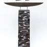Black ship with white grey sails on a black grey and white column. The ceramic ship and the column are coated with layers of colored slips, glaze and ceramic pigments, thus creating an alternating glossy or matt surface.