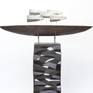 Black ship with white grey sails on a black grey and white column. The ceramic ship and the column are coated with layers of colored slips, glaze and ceramic pigments, thus creating an alternating glossy or matt surface.