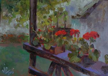 Red geraniums on a bench thumb