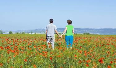 Couple on meadow with red poppies thumb