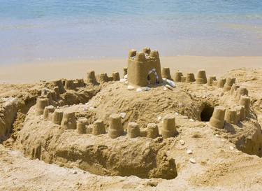 Sandy castle on sea beach thumb