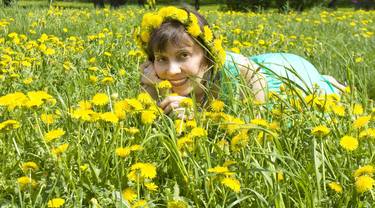 Beautiful woman on meadow with dandelions thumb