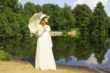 Woman in white historical dress near lake thumb