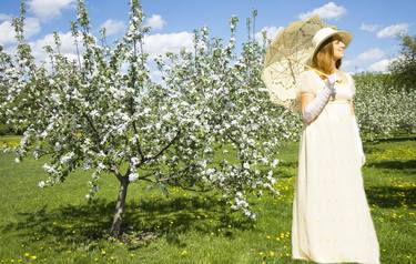 Woman in white dress in apple garden thumb