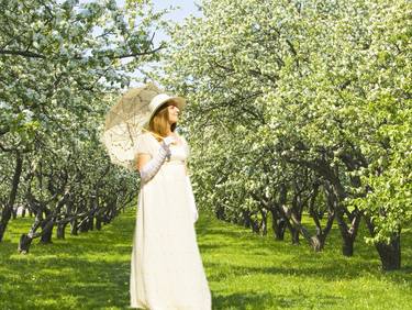 Woman in white in apple garden in blossom thumb