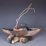 This in one in a series of vessel sculptures using my alternative method of firing to achieve the color and patterning that occurs organically. There is contradiction in meaning of the shapes in the stationary nature of rock and the movement of a boat-shaped vessel meant to carry along.