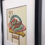 framed in a simple black square edge frame with plexiglass.