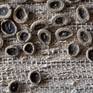 This is a woven piece with a silk warp. The weft is based of a cotton-silk yarn, fique (a sturdy plant fiber) and hand made ceramic buttons.