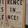 "Indifference lives in...silence!" is carved on an old music sheet. The single letter fallen in front of the book.