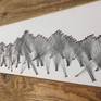 A profile of mountains created with threads and nails on wood