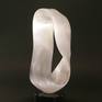 Selene was carved from Moroccan Selenite, a crystallized form of gypsum. Despite the name, selenite does not contain a significant amount of selenium; the similarity comes from both substances being named after the ancient Greek goddess of the Moon. This piece is a very straightforward Mobius strip, having only one surface and one edge in the classing Mobius shape. This mathematical shape was discovered in 1858 by German mathematician and astronomer August Ferdinand Mobius.