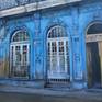Colonial building in Old Havana painted in striking blue color that shows the state of neglect and lack of maintenance.