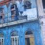 Colonial building in Old Havana painted in striking blue color that shows the state of neglect and lack of maintenance.