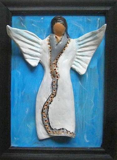 Ceramic angel on a blue background .. thumb