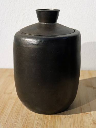 Large bronze vessel with lit thumb