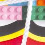 Word pun in Italian.

Word and matter together. The declared action ("I tie") of an instrument (the rope) acts on the famous brand of bricks.
Here, in a new coloured and fun small-size version.