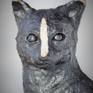 The black cat with white stripe in the middle of face.

Sculpture made by fireclay. It can be placed on garden for whole year or inside.