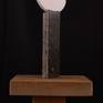 This "lamp-like" abstract sculpture of highly polished stone on stone sits on a small wooden base.